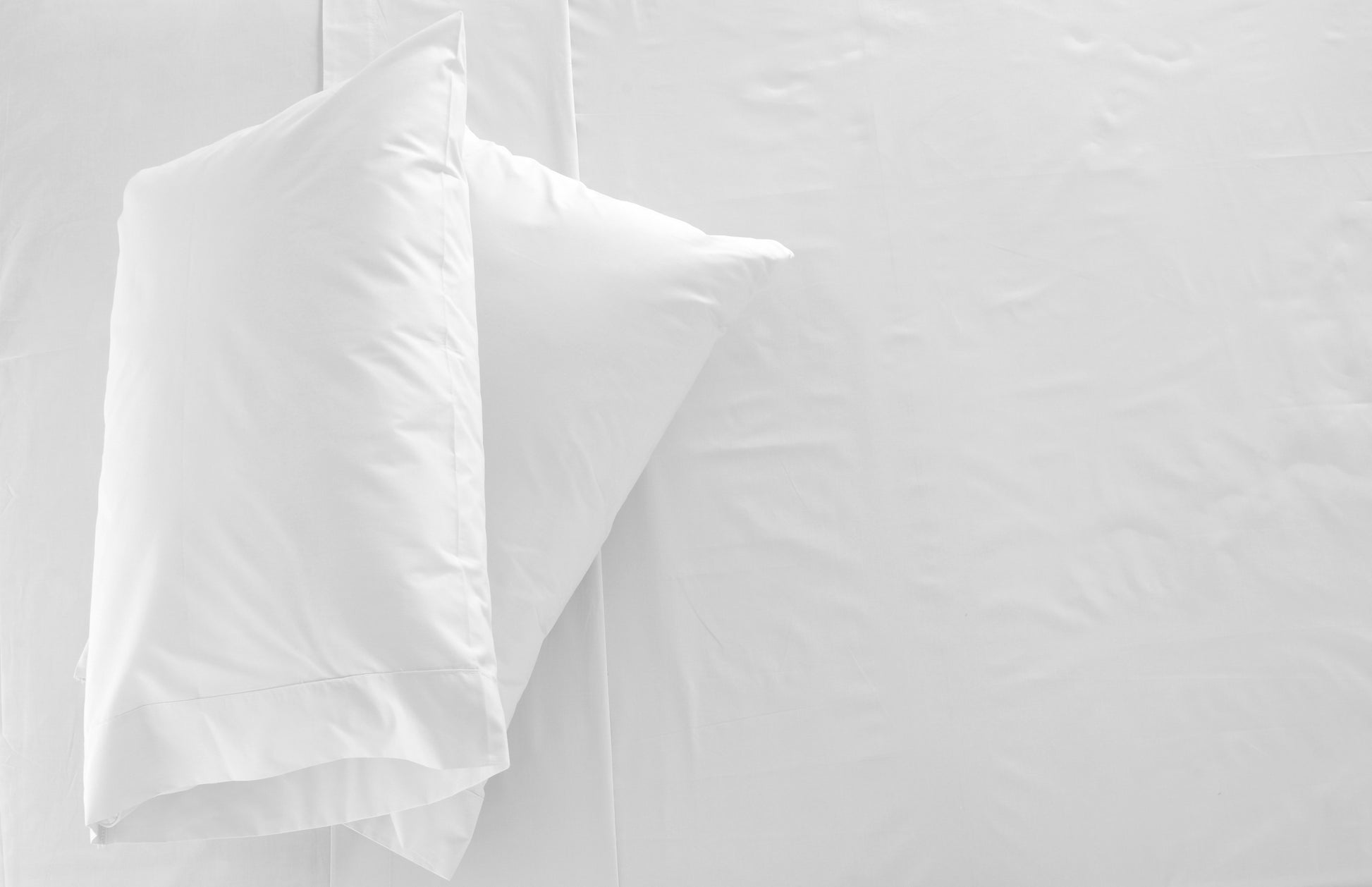 2 oreillers blanches sur un lit blanc