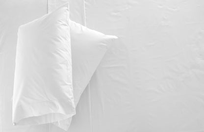 2 oreillers blanches sur un lit blanc
